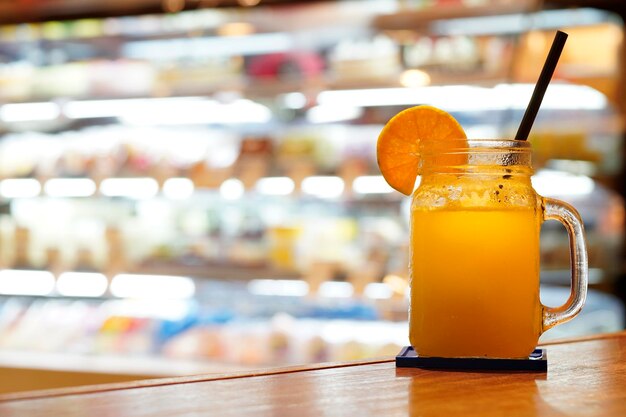 Un verre de jus d'orange avec un arrière-plan flou lumineux