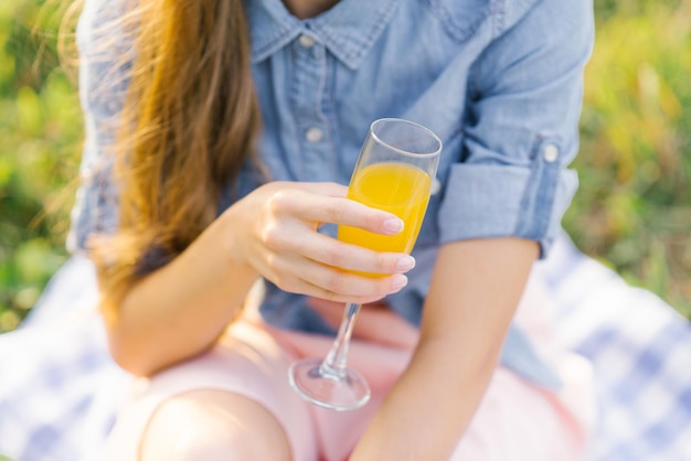 Verre de jus d'orange dans la main d'une jeune femme