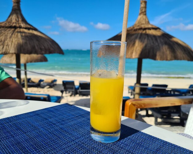 Un verre de jus d'orange est sur une table en bois