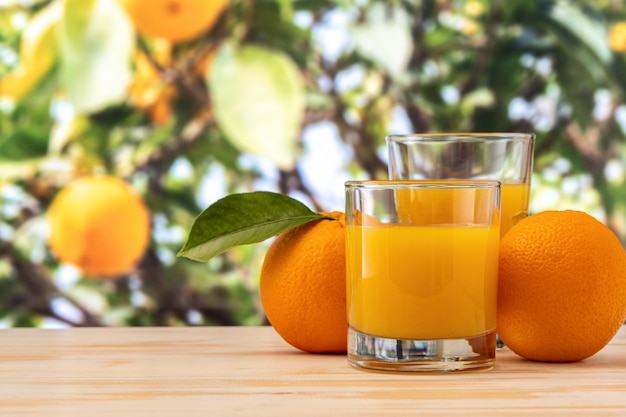 Verre de jus d'orange à l'extérieur sur table en bois