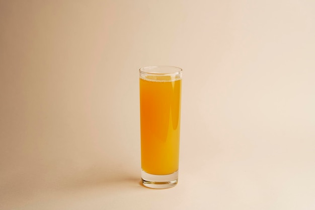 Verre de jus d'orange sur fond de couleur pastel