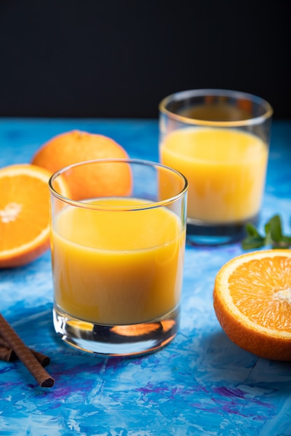 Verre de jus d'orange sur fond noir et bleu. Vue latérale, gros plan.