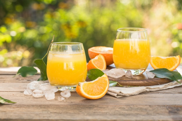 Verre de jus d'orange frais, fruits orange mûrs et tranches sur naturel. Jus d'orange fraîchement pressé avec de la paille, des fruits orange et des tranches d'orange.