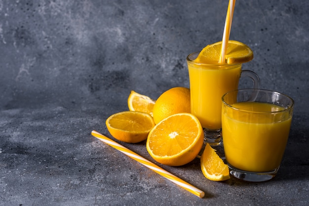 Photo verre de jus d'orange frais, fruits et tranches d'orange mûre