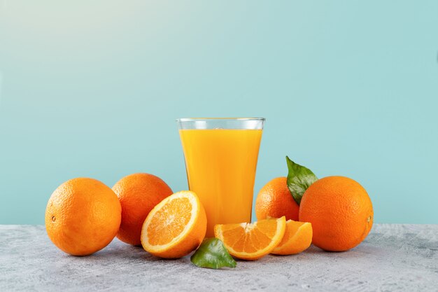 Verre de jus d'orange frais et oranges