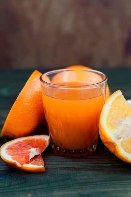 Verre de jus d'orange et un groupe d'oranges sur un tableau noir