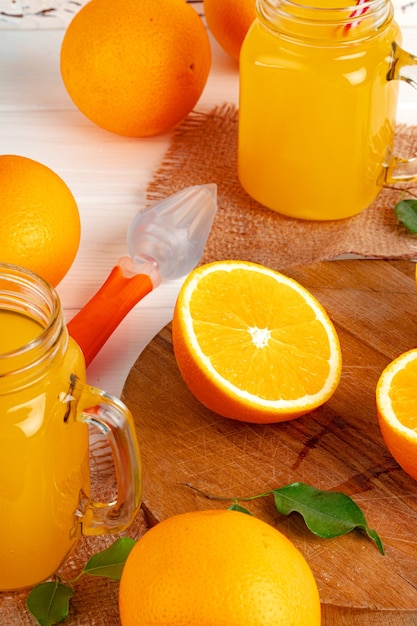 Verre de jus d'orange et oranges coupées sur table