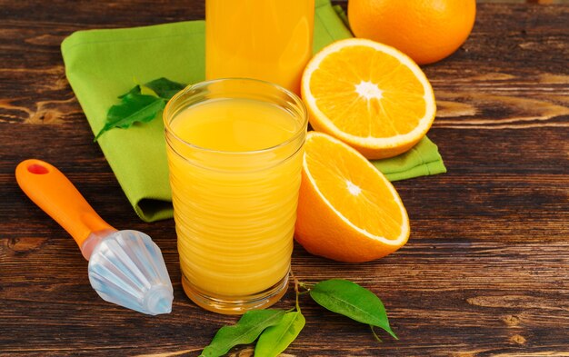 Verre de jus d'orange sur table en bois se bouchent