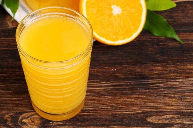 Verre de jus d'orange sur une table en bois se bouchent