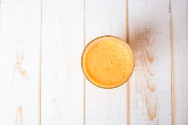 Un verre de jus d'orange sur table en bois