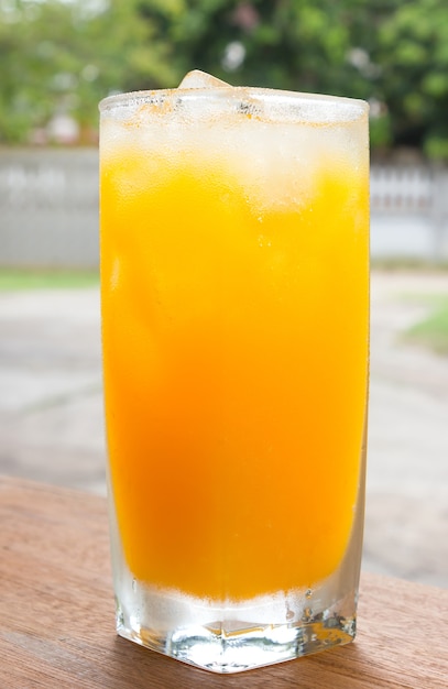 Photo verre de jus d'orange sur la table en bois.