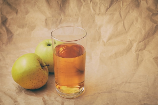 Un verre de jus de pomme avec des pommes