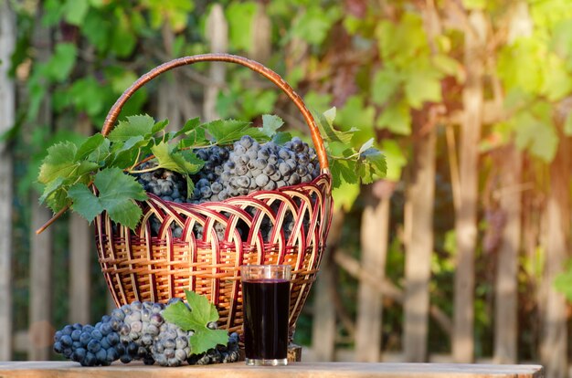 Verre de jus de raisin avec panier en osier de raisin