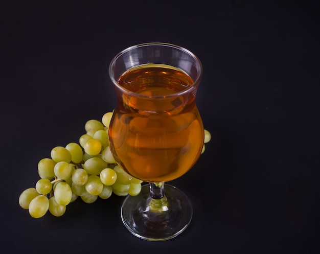 Verre de jus de raisin vert ou de vin blanc avec grappe de raisin