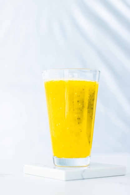 Verre de jus de smoothie aux fruits jaunes avec des graines de chia pour une recette de petit-déjeuner parfaite de désintoxication diététique