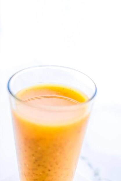 Verre de jus de smoothie aux fruits orange avec des graines de chia pour une recette de petit-déjeuner parfaite pour une désintoxication diététique