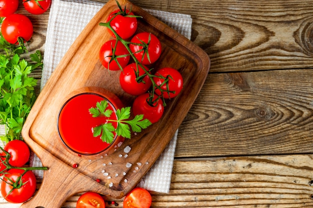 Verre de jus de tomate fraîche sur le bois