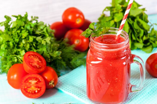 Verre de jus de tomate rouge sur une table en bois