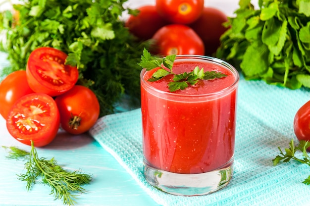 Verre de jus de tomate rouge sur une table en bois