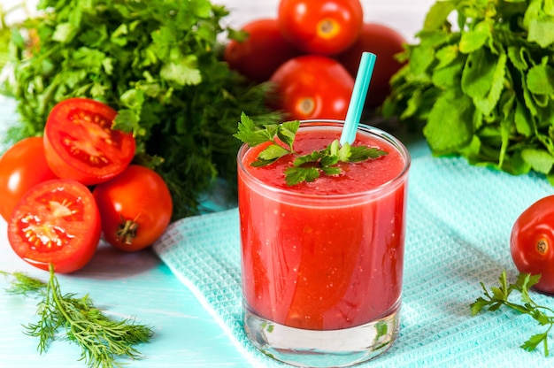 Verre de jus de tomate rouge sur une table en bois