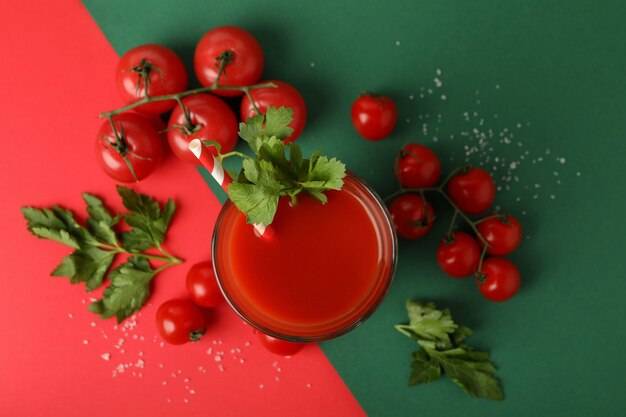 Verre de jus de tomate et tomates sur fond bicolore