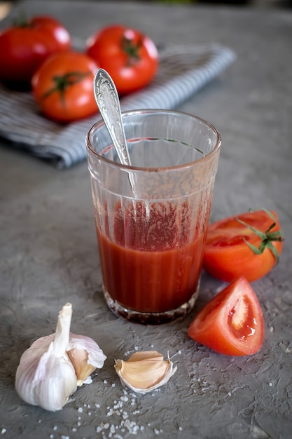 Verre de jus de tomates fraîches, tomates et ail