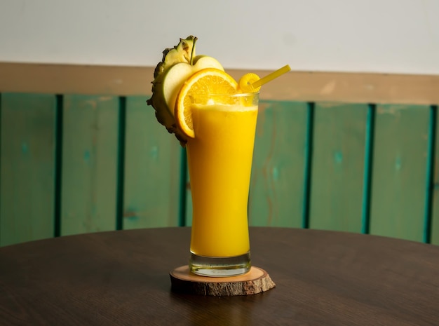 Un verre de jus Tropical Twist shake de soda cocktail orange pomme ananas avec fruits crus