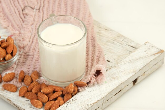 un verre de lait d'amande avec de l'amande sur un fond clair