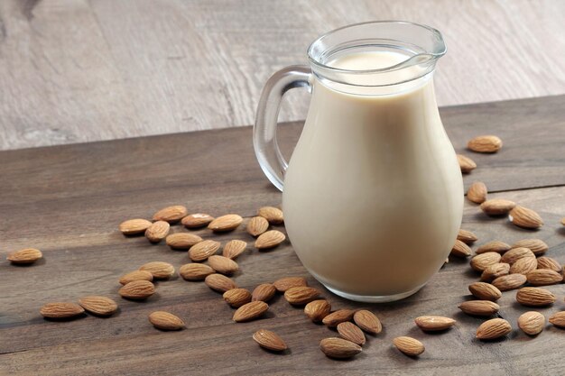 Un verre de lait d'amande est sur une surface en bois.