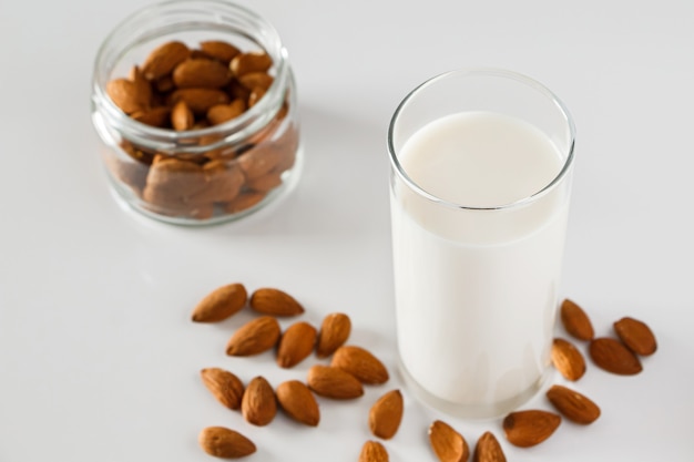 Verre de lait d'amande sur fond blanc Super aliment sans lactose pour une alimentation saine