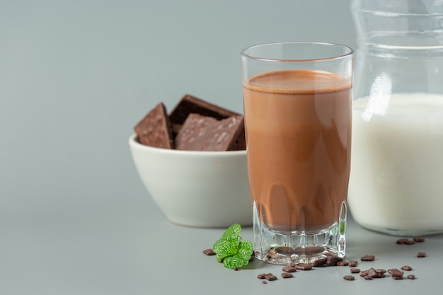 Verre de lait au chocolat sur la surface sombre.