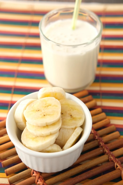 verre de lait et banane sur table le matin