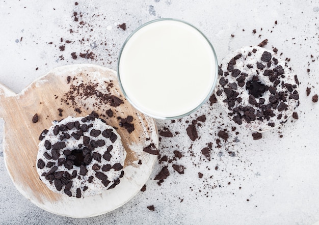 Verre de lait et beignets avec biscuits noirs sur table de cuisine en pierre.