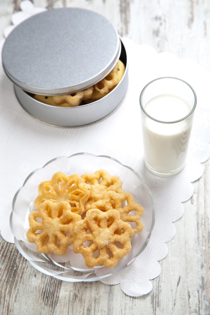 Verre de lait et biscuits sur une assiette.