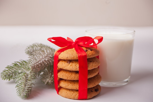 Verre de lait, biscuits et branche d'arbre de Noël