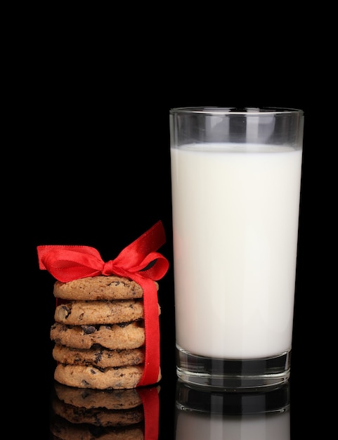 Verre de lait et biscuits isolés sur fond noir