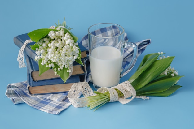 Verre à lait sur le bleu avec des fleurs