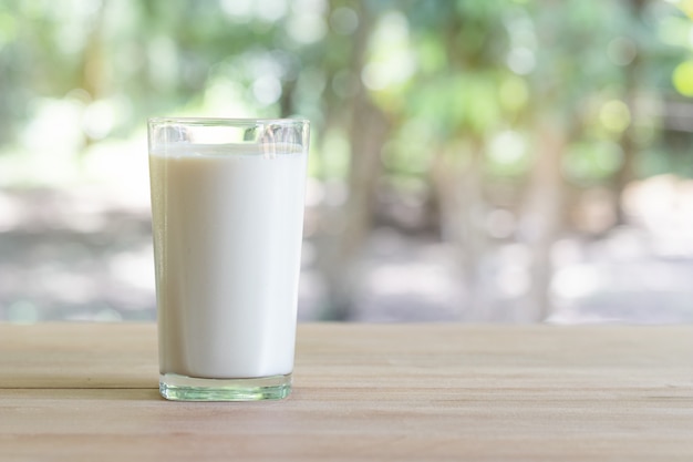 Verre de lait sur le bureau avec fond de nature.