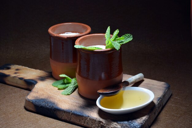 Verre de lait caillé avec une cuillère en bois et feuilles de menthe