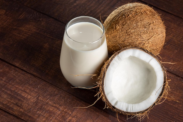 Verre de lait de coco avec des morceaux de noix de coco sur la table