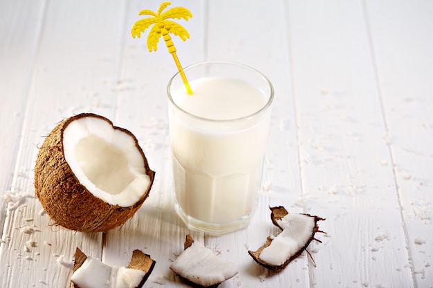 Verre de lait de coco sur table en bois blanc