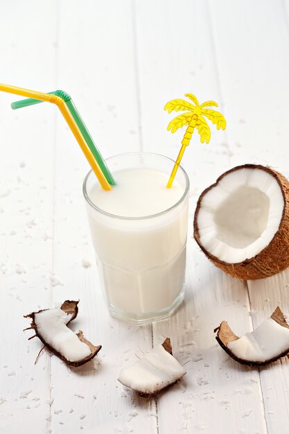 Verre de lait de coco sur une table en bois blanche. Mise au point sélective