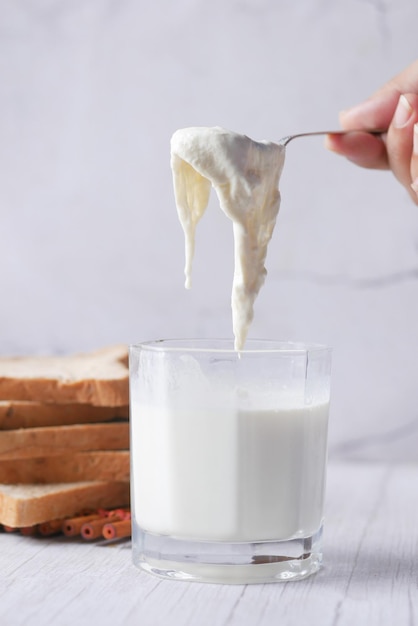 Verre de lait entier sur crème de lait de table