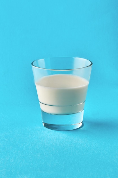 Verre de lait sur fond bleu