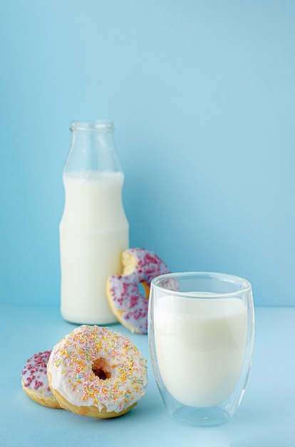 Verre de lait frais bio et dessert glacé sur fond bleu