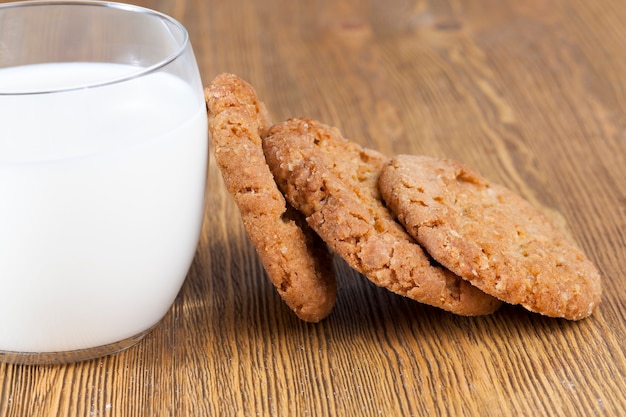 Un verre de lait frais blanc et des biscuits croustillants faits maison sur la table, cuisine de cuisine