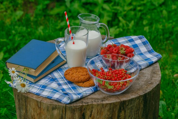 Verre de lait frais avec des framboises fraîches mûres pour le petit déjeuner sur une surface en bois