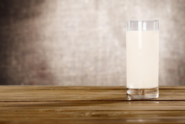 Photo un verre de lait frais sur une table en bois