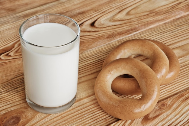 Verre de lait frais et trois bagels sur table en bois Concept de petit-déjeuner matinal