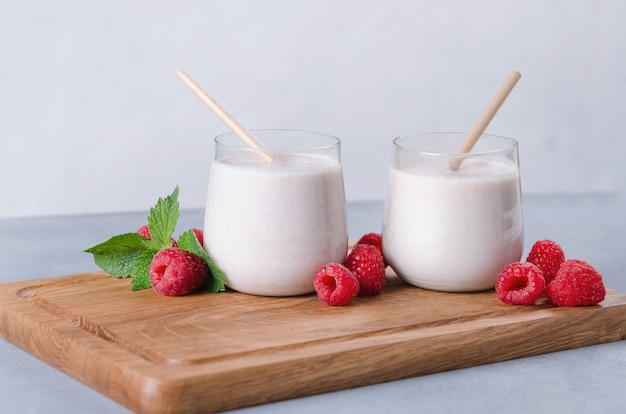 Verre de lait frappé aux framboises sur planche de bois